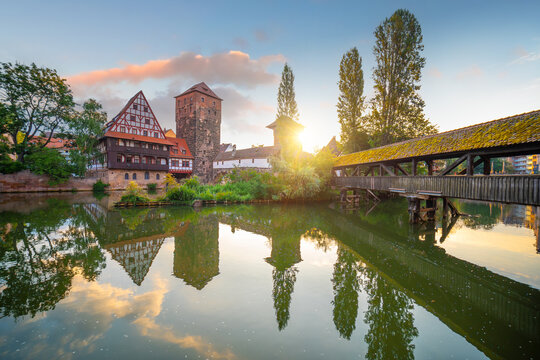 Stunning sunset view of the historic Weinstadel, Henkersteg wooden bridge  reflecting in the calm waters of the Pegnitz River in Nuremberg