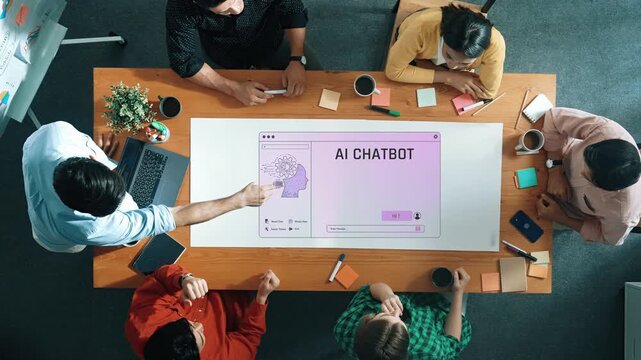 A diverse team collaborates on developing an AI chatbot in a modern office space, engaging in discussion and brainstorming innovative ideas while using digital technology. Raster