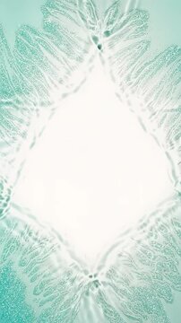 【縦型動画】爽やかなミントグリーンの水面が涼しげに揺れ動き菱形の枠を作るみずみずしいフレーム背景素材。化粧水の浸透感や清涼感、オーガニックなスキンケアの魅力を伝える9:16のクリーンなデザイン。中央の白いスペースに文字や動画を重ねやすい縦型コスメプロモーション素材