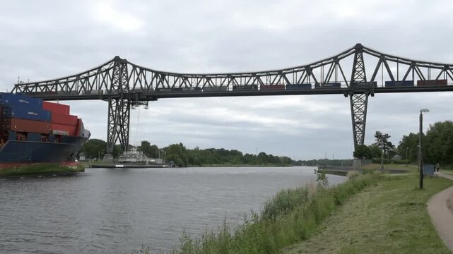 Cargo ship sailing under Rendsburg high bridge in Kiel Canal, Schleswig-Holstein, Germany