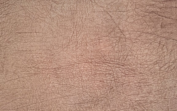 Dark Brown leather background with cracked texture full frame faux leatherette grain pattern.