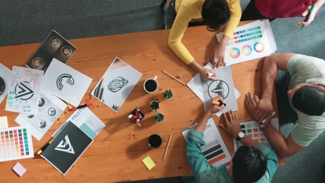 Top view of manager writing idea on sticky notes and explain idea about web design. Professional marketing team or programmer brainstorming idea while looking at tablet with color palette. Symposium.