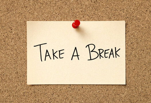 Encouraging note saying take a break pinned on cork board