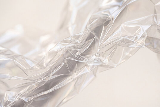 crumpled transparent plastic foil texture on soft neutral background