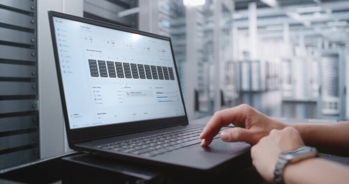 Female Network Engineer Reviews Server Monitoring Dashboard, Identifying Critical Rack Overheating and Checking Environmental Metrics, System Health, Power, Cooling and Resource Loads During Response.