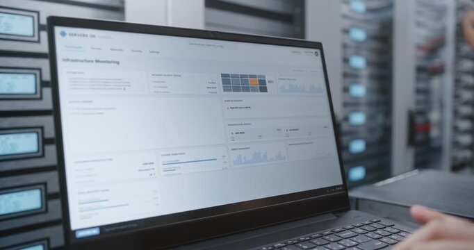 IT Engineer Reviews Infrastructure Dashboard Showing Firewall Status, SSL Certificate Validity, DDoS Protection, Cooling Fan Speed, Server Temperature and Network Traffic Across Data Center Systems.