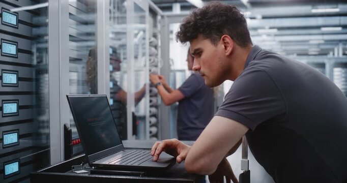 Male Cybersecurity Specialist Investigates DDoS Incident Through Terminal Interface, Monitoring Server Behavior and Applying Emergency CLI Procedures to Protect Enterprise Infrastructure From Attack.
