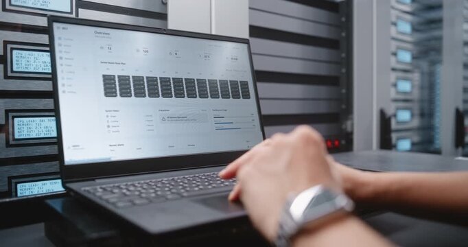 IT Specialist Analyzes Data Center Incident Dashboard on Laptop, Locating Overheated Server and Reviewing Temperature, CPU, Memory, Bandwidth and Infrastructure Status During Technical Response.