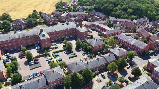 Aerial drone view of Knowle Village near Fareham, Hampshire, featuring converted Victorian red-brick former hospital buildings and modern residential housing surrounded by green fields.