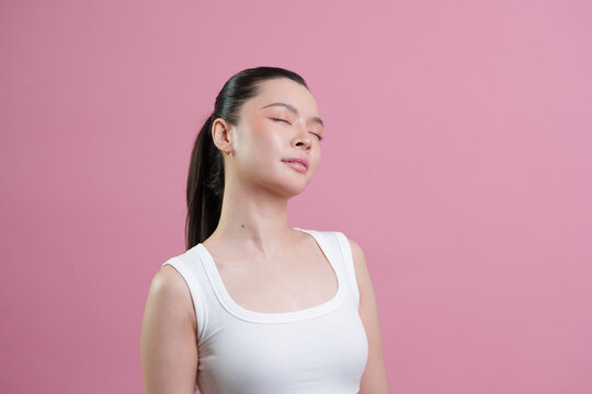 Serene Asian woman with closed eyes enjoying fresh skin for beauty and skincare wellness
