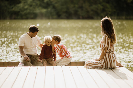 Joyful family moments by the tranquil lake on a sunny afternoon