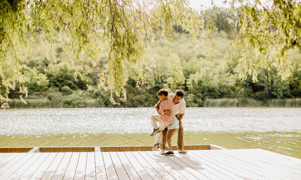 Couple enjoys a sunny day on a peaceful lakeside deck