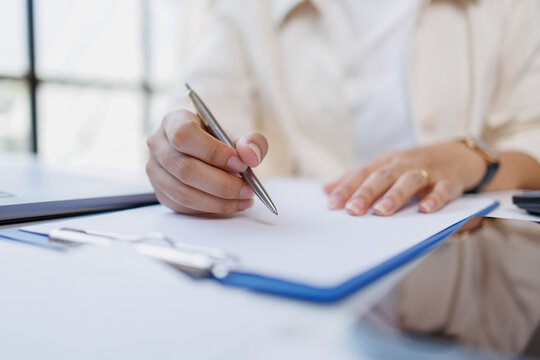 Person hand writing document on clipboard, signing contract or filling out form, performing administrative task, planning business strategy, making notes, close up
