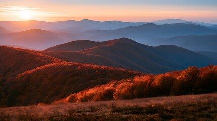 Obraz premium Sunset over colorful autumn mountain range with golden light on forest ridges and blue valleys