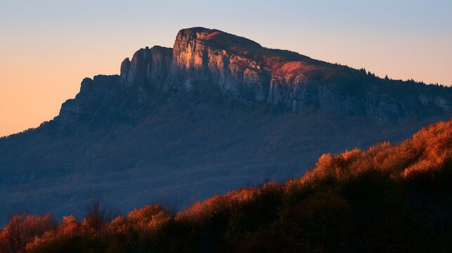 Golden morning light illuminating the rugged rocky summit and autumn forest of mount katahdin
