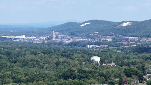 The Freedom Tower rises over the brick campus of Liberty University at Lynchburg, Virginia, the white synthetic slopes of the Snowflex Centre cut into Liberty Mountain behind. Aerial view