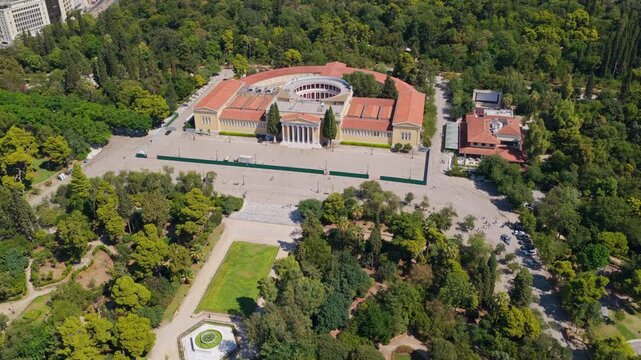 High aerial shot revealing the impressive neoclassical Zappeion Hall, an iconic landmark surrounded by the lush National Garden in the heart of Athens, Greece, on a sunny day