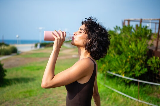 Woman drinking water outdoors staying hydrated and refreshed
