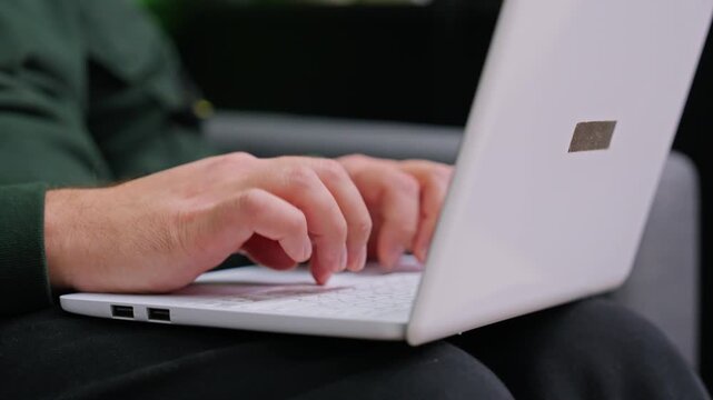 Typing on a laptop in a modern setting during the day