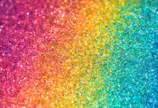Colorful glitter particles displaying vibrant rainbow gradient texture close up