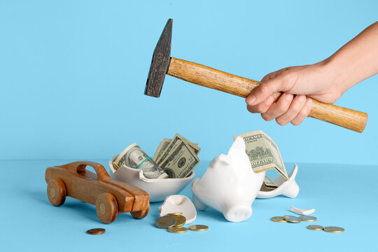 Financial crisis and debt, broken piggy bank with cash and wooden car toy loss of savings and inability to afford vehicle maintenance