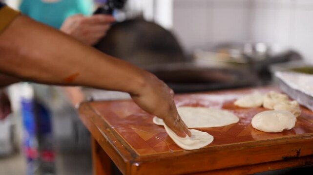 Chef Kneading and Flattening Dough to Prepare Traditional Flatbread