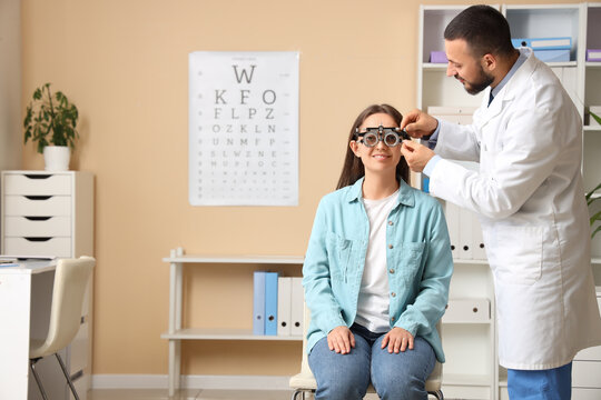 Eye exam and vision care, optometrist performing vision test for young woman with trial frame glasses in medical clinic office for health checkup
