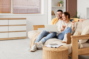 Online shopping and e-commerce, happy couple using laptop and credit card for digital payment while...