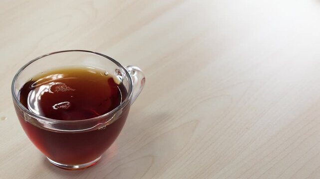 Dropping Sugar Cubes with Tongs into Glass Cup of Black Tea