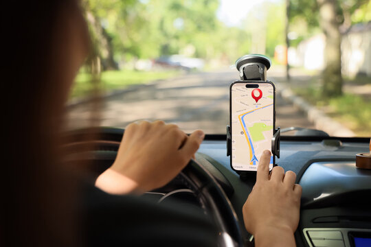 Navigation and gps tracking, driver using smartphone map app for route planning and location finding while driving car on suburban road