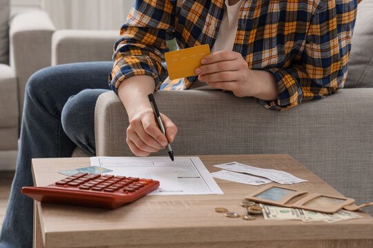 Personal finance and debt management, person filling out financial forms with credit card and calculator at home to manage household budget and expenses