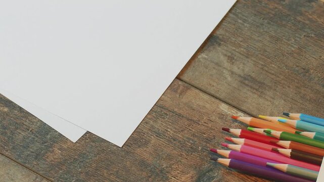 Colored pencils and blank paper are ready for drawing at the table today