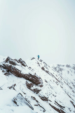 Mountaineer using an ice axe to climb Forcan Ridge in Glen Shiel, Scotland