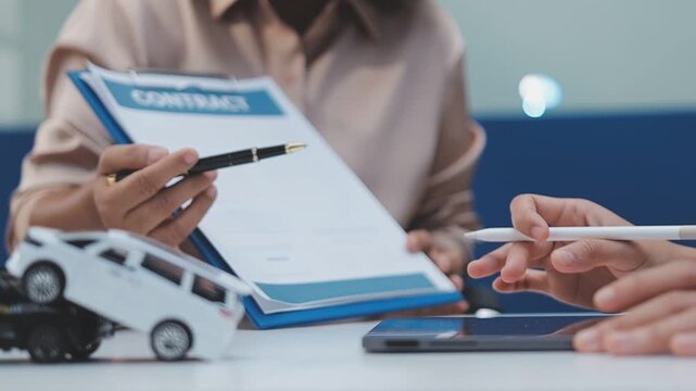 Businessperson signing car purchase agreement with vehicle model and key on contract documents, symbolizing auto financing, ownership transfer, and insurance planning.
