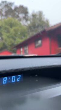 dashboard shot of a person pulling out a driveway and driving away down the street