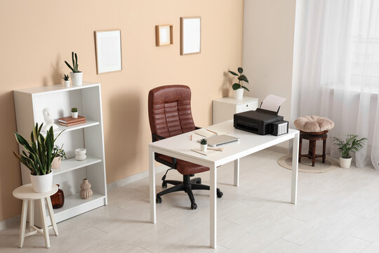 Workplace with modern printer, laptop and comfortable chair in stylish home office