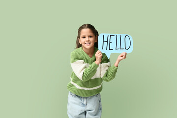 Cute little happy girl holding paper speech bubble with word HELLO on green background © Pixel-Shot