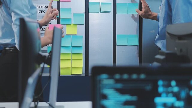 Asian happy woman and man programmer team coding software at computer in dark tech office, Concept of digital transformation, modern cyber security, startup teamwork and future IT digital network