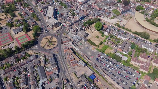 Circling aerial shot over Colchester town train station and st Botolphs circus roundabout