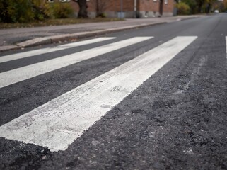 Obraz premium White Pedestrian Crosswalk Stripes Painted on Asphalt Road Surface for Traffic Safety and Walking Crossing Pathway in Urban City Environment