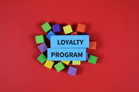 Colorful wooden blocks with &ldquo;LOYALTY PROGRAM&rdquo; text on an red background, representing customer retention, rewards, marketing, and business loyalty concepts.