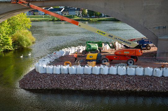 Construction site railway bridge Wasserbillig, Luxembourg, excavators and road roller, temporary bank reinforcement, sandbags and crushed stone