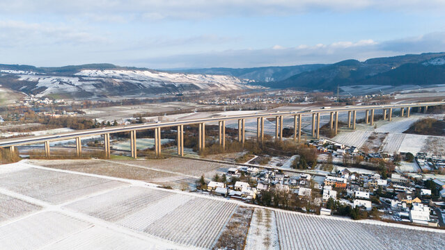 Moselle vineyard, Viaduct Longuich, Mosel valley, snow in winter season, bridge of highway crossing river near Trier, aerial view