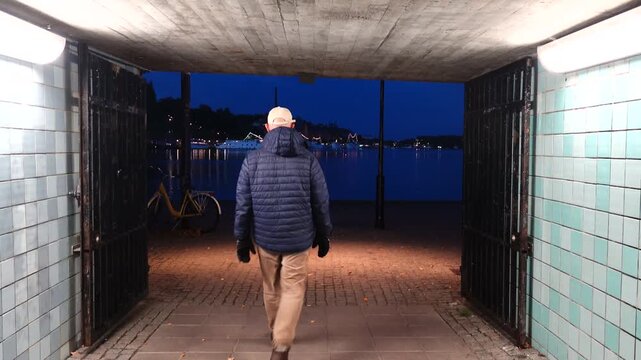 Stockholm, Sweden A man walks in a corridor leading to the Riddarfjarden bay at night in Gamla Stan, or Old Town. 