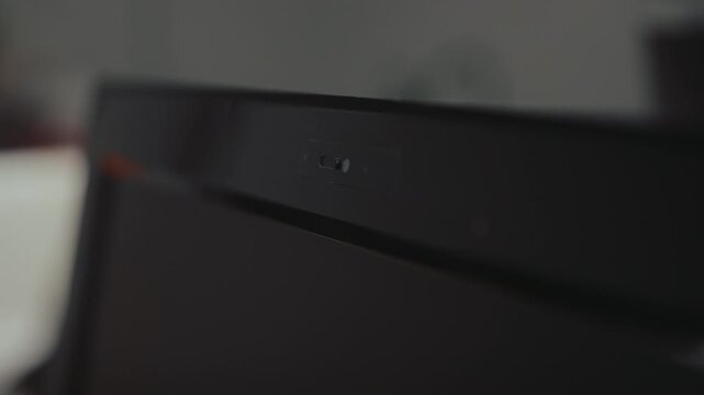 Closeup of human finger opening and closing built in privacy shutter on portable computer webcam, crucial measure for ensuring online safety, preventing spying, maintaining digital confidentiality.