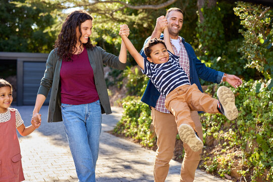 Happy parents holding hands of  joyful jumping son