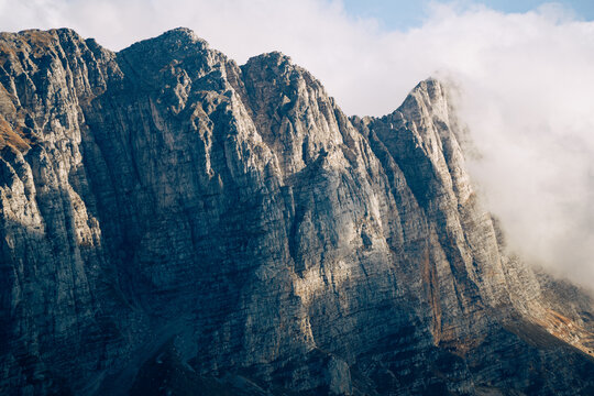 Rugged rocky mountain face with passing clouds