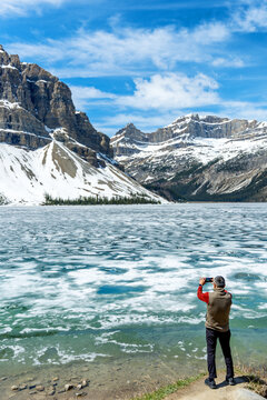 Man photographing frozen Bow Lake in Banff National Park