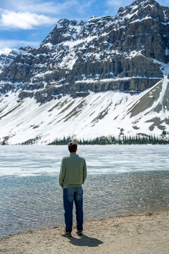 Man observing frozen Bow Lake in Banff National Park in Canada