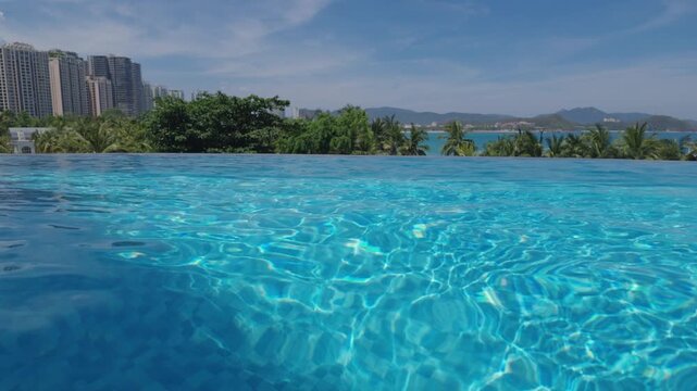 Fresh swimming pool in suburban house in tropical garden, save of abnormal heat. Rest in paradise, relax in villa with view on modern city on seacoast, enjoy solitude and calmness, hot summer day